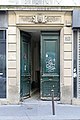 Rue des Petites-Écuries (Paris). Porte du numéro 29, bas-relief au linteau (mascaron barbu, branches de laurier).