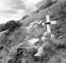 Memorial cross marking the spot where smokejumper Joseph B. Sylvia was fatally burned while fleeing the advancing wildfire--13 memorial markers are located on the steep hillside. SYLVIA Joseph B memorial at Mann Gulch fire site Montana.png