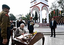 The Prime Minister, Narendra Modi, signing the visitors' book at the War Memorial in Indian Military Academy. The Prime Minister, Shri Narendra Modi signing the visitors' book, at the War Memorial in Indian Military Academy, Dehradun, ahead of the Combined Commanders Conference,.jpg