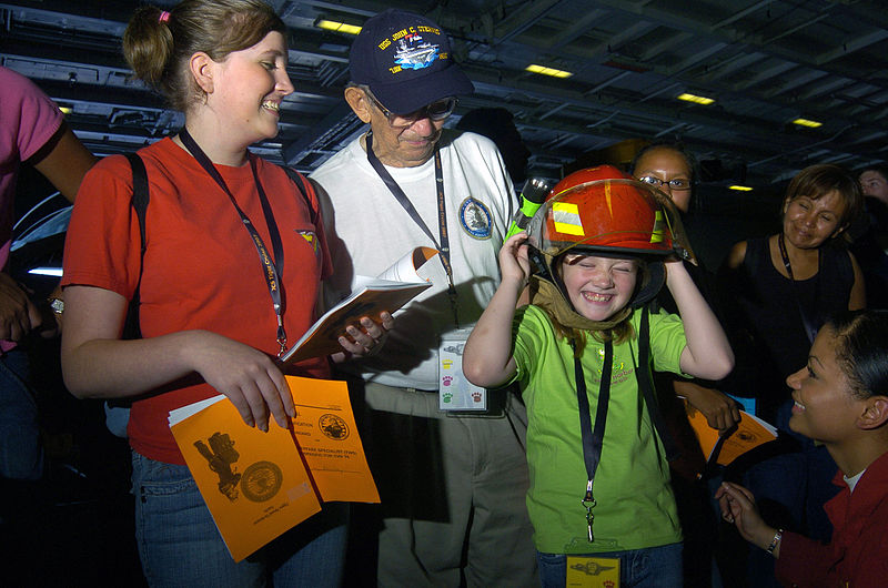 File:US Navy 070822-N-3038W-181 Damage Controlman 3rd Class Felicity Prestianni, right, from engineering department's damage control division, helps a young Tiger try on a firefighting helmet that is part of a fire fighting ensemble.jpg