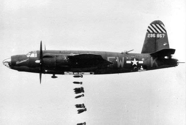 The way the line of bombs falling from this B-26 goes towards the rear is due to drag. The aircraft's engines keep it moving forward at a constant spe