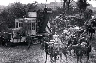 Немецкий военный траншейный экскаватор (роторного многоковшового типа) на базе шасси тяжёлого танка A7V, 1918 год. На заднем плане — аналогичная машина с открытой кабиной, замаскированная ветками