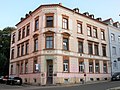 Tenement house in a corner and half-open development, with lateral fencing