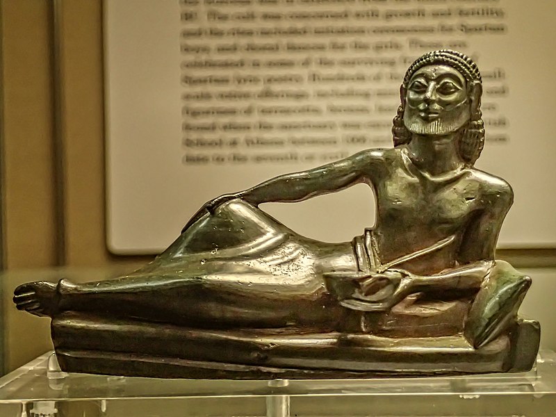 File:Bronze banqueter from the tripod support of a bronze bowl Laconian 530-500 BCE from Dodona British Museum.jpg