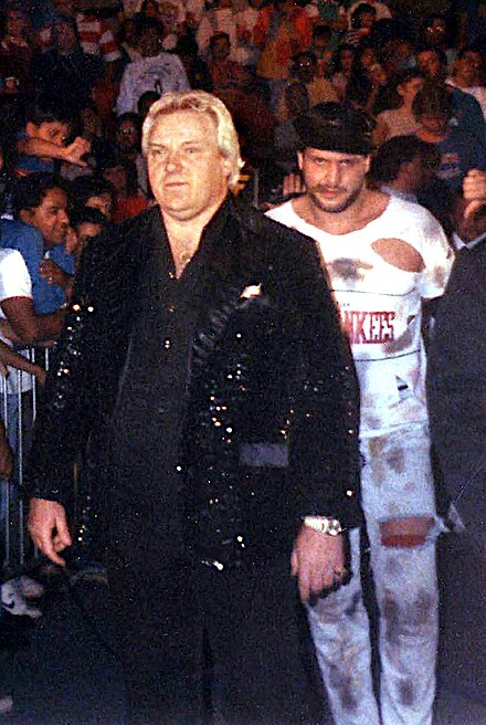 Heenan became a commentator while in the World Wrestling Federation, but continued to manage various wrestlers, such as The Brooklyn Brawler (behind Heenan)