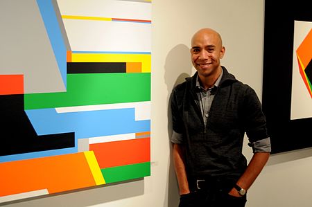 Bryce-hudson-standing-next-to-one-of-his-large-geometric-paintings.jpg