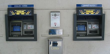 Two NCR Personas 84 ATMs at a bank in Jersey dispensing two types of pound sterling banknotes: Bank of England on the left, and States of Jersey on the right