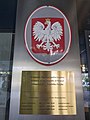 The coat of arms of Poland in Zagreb. The grey oval plate made of metal sheet is visible. The grey oval plates are popular in schools and embassies on facades, but ovals are considered as ordinary