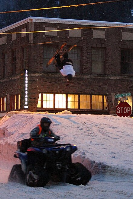 Tracked ATVs pull skiers through obstacles and jumps along a historic downtown.