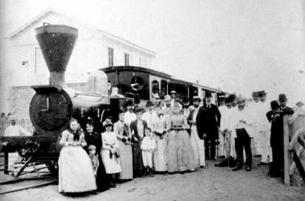 Passengers posing in front of the "Ferrocarril de Manila y Dagupan" (c. 1885).