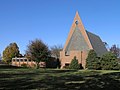 Церковь из красного кирпича с треугольником угловой фасад и высокая покатая крыша 