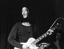 Black and white photo of Peter Green from the waist up playing a Les Paul Gibson with a reversed neck pickup