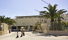 Un edificio blanco con techo plano, protegido por barandillas.