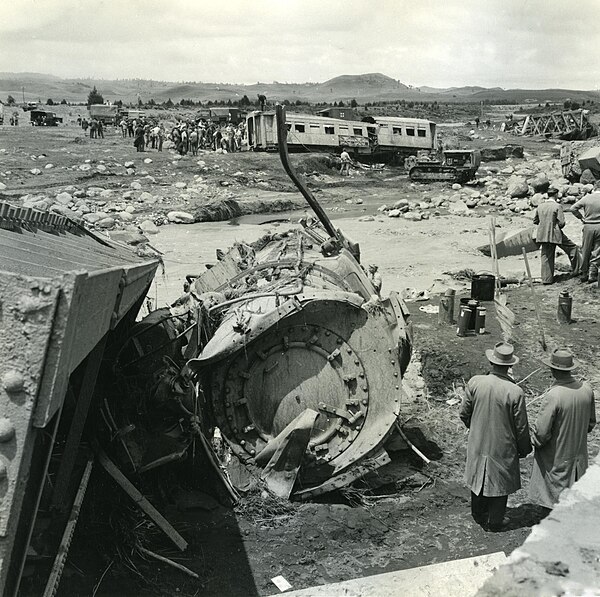 The wreckage of the KA locomotive, the sixth carriage and the rail bridge, in the Whangaehu River at Tangiwai, 25 December 1953.