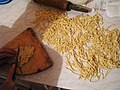 Kyrgyz kesme dough being cut into noodles.