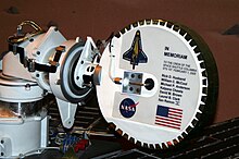 The Mars rover Spirit contains a memorial to the crew of the Space Shuttle Columbia's STS-107 2003 mission, which disintegrated upon reentry. MER STS-107 Memorial.JPG