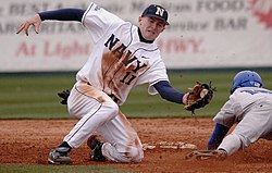 A shortstop attempts to tag out a player sliding head-first into a base Navy baseball.jpg