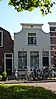 Woonhuis met wit gepleisterde afgeknotte klokgevel en een mansardedak (Gouda-Centrum)