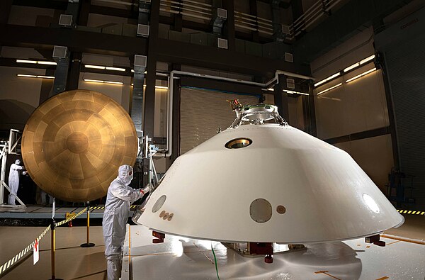 The heat shield (left) and back shell (right) together make up the aeroshell for NASA's Mars 2020 mission. The diameter of each part is about 15 feet 