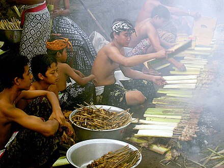 Balinese men preparing pork satay during traditional ceremony in Tenganan village, Karangasem