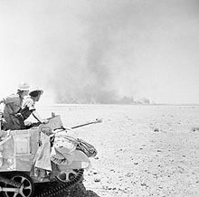 Men of the 9th Battalion, Rifle Brigade watch the destruction of a British supply dump at Hamra, El Alamein. The Campaign in North Africa 1940-1943 E13994.jpg