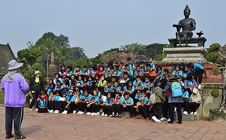 A school group poses in front of the King Ramkhamhaeng Monument