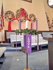 On Christmas Day, the Christ Candle in the center of the Advent wreath is traditionally lit in many church services and Christmas dinners. Advent Wreath (Broadway United Methodist Church).jpg