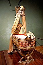 King of Rome's Cradle; by Pierre-Paul Prud'hon, Henri Victor Roguier, Jean-Baptiste-Claude Odiot and Pierre-Philippe Thomire; 1811; wood, silver gilt, mother-of-pearl, sheets of copper covered with velvet, silk and tulle, decorated with silver and gold thread; height: 216 cm; Kunsthistorisches Museum, Vienna, Austria[76]
