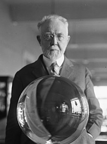 George P. Merrill, head curator of the National Museum, with the largest perfect crystal globe in the world, Washington, D.C. (cropped).jpg