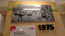 A museum exhibit about the Groningen Grote Markt shows a post-WWII bicycle lane that forced cyclists to merge with motorists. This design was eventually removed. Groningen Grote Markt 1975 Museum Exhibit.jpg