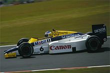 Photo d'une monoplace de Formule 1, bleue, jaune et blanche, sur une piste de circuit