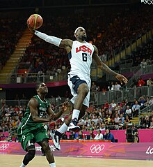 LeBron James part au dunk en contre-attaque devant un défenseur de l'équipe du Nigéria.