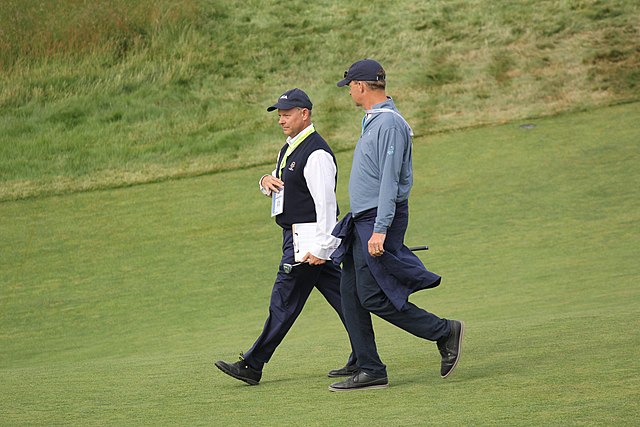 Mike Davis (on left), former executive director of the USGA, walking down the 18th fairway at the 2018 U.S. Open.