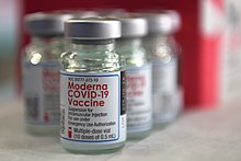 Vials containing the Moderna COVID-19 vaccine sit on a table in preparation for vaccination