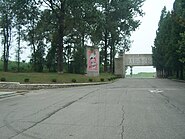 Looking back toward the same entrance. An anti-tank measure carries the slogan: "Reunification without outside interference".