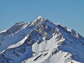 Vy över Rateau d'Aussois (mitt) som domineras av spetsen av stegen (bakgrund) från höjderna i La Norma.