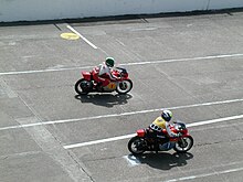 Photo de Giacomo Agostini et de Kenny Roberts pilotant sur le circuit de Monthléry.