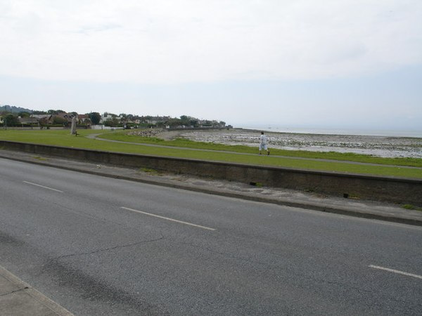 Strand Road coastal pathway and Luí na Gréine standing stone in the distance