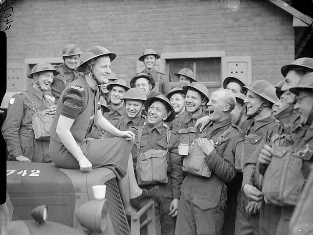 Fields shares a joke with troops in a village near Valenciennes, France, April 1940