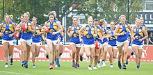 A group of female Australian rules footballers jogging together