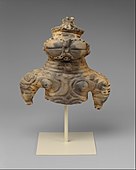 Dogū; 1000–300 î.Hr.; ceramică; înălțime: 16,5 cm, lățime: 16,2 cm, adâncime: 7,9 cm; Muzeul Metropolitan de Artă (New York City)