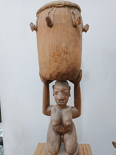 File:A statue of a woman carrying a drum.jpg