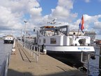 Amsterdam photo of ships and boats, free download; a transport ship has docked in the old harbour Oude Houthaven under a blue cloudy sky. Fons Heijnsbroek, street photography of The Netherlands in high resolution; free image