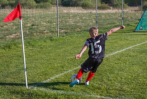 Boy taking a corner kick during a little league soccer game in Brastad arena