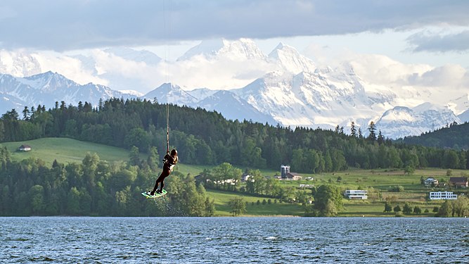 kitesurfer on lake zug, in zug, switzerland. In the background you can see the mountains mönch, eiger and jungfrau