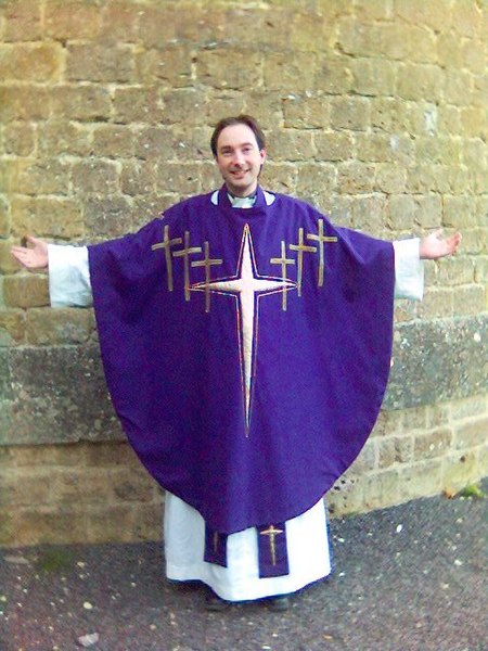 An Anglican priest wearing a modern chasuble over alb and stole