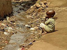 Child next to open sewer in slum in Kampala, Uganda, at risk of diarrhea and stunted growth Child in slum in Kampala (Uganda) next to open sewage (3110617133).jpg