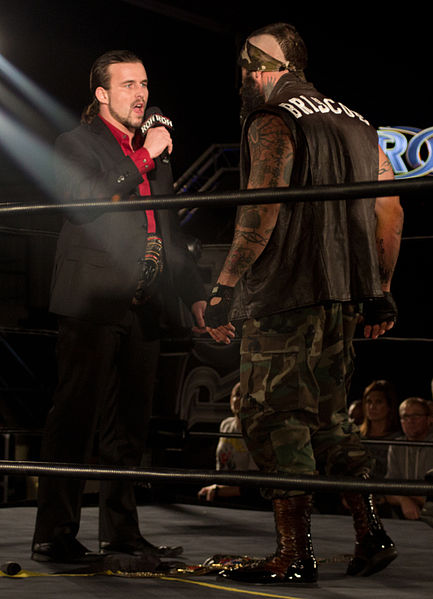Briscoe (right) confronting Adam Cole over which one is the real ROH World Champion in January 2014.