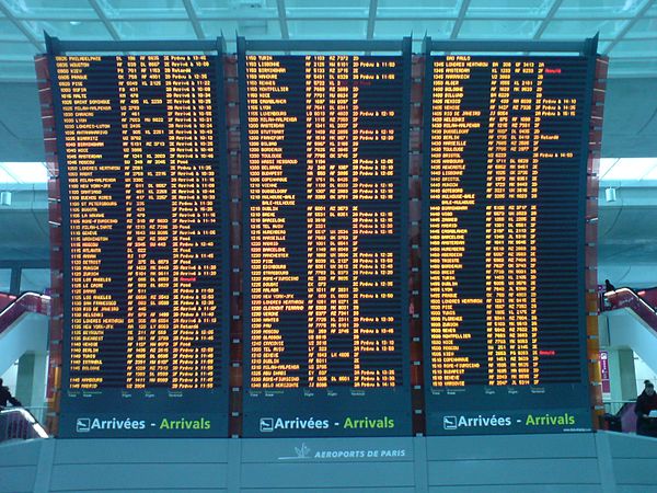 A flight information display system screen at Charles de Gaulle Airport's Terminal 2 showing flight arrivals