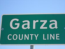 Vue d'un panneau vert sur fond blanc avec inscription Garza County Line.